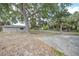 Large backyard with mature trees, concrete patio, and storage shed at 23165 Glen Ave, Punta Gorda, FL 33980