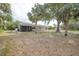 View of the home’s screened-in patio and large backyard dotted with mature trees, offering a blend of comfort and nature at 23165 Glen Ave, Punta Gorda, FL 33980