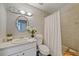 Bathroom with a vanity, mirror, toilet, and a bathtub with a shower curtain, offering a functional layout at 23165 Glen Ave, Punta Gorda, FL 33980