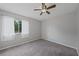 Bedroom featuring neutral walls, plush gray carpet, large window, and white window curtains at 23165 Glen Ave, Punta Gorda, FL 33980
