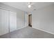 Bedroom featuring neutral walls, plush gray carpet, white ceiling fan, and double door closet at 23165 Glen Ave, Punta Gorda, FL 33980