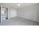 Bright bedroom featuring neutral walls, plush gray carpet, and a white ceiling fan at 23165 Glen Ave, Punta Gorda, FL 33980