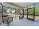 Relaxing screened porch with outdoor chairs offering serene views of lush greenery at 23165 Glen Ave, Punta Gorda, FL 33980