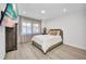Bedroom featuring modern tv, light fixtures, and large window view to the outdoors at 232 W Henry St, Punta Gorda, FL 33950
