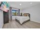 Comfortable bedroom featuring light wood flooring, a window, and a wall-mounted TV at 232 W Henry St, Punta Gorda, FL 33950