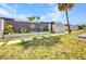 Front exterior view of a home featuring a decorative fence, lush landscaping, and a well-manicured lawn at 232 W Henry St, Punta Gorda, FL 33950