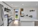 Contemporary kitchen with stainless steel appliances, white cabinetry, and a view to the backyard at 232 W Henry St, Punta Gorda, FL 33950