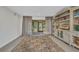 Bright living room with large area rug, custom bookshelf, and natural light from the sliding glass door at 232 W Henry St, Punta Gorda, FL 33950