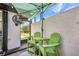 Charming patio with green Adirondack chairs and table under a shade umbrella and ceiling fan at 232 W Henry St, Punta Gorda, FL 33950