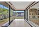 Enclosed sunroom offers tile flooring and a view of the backyard and building beyond at 232 W Henry St, Punta Gorda, FL 33950