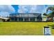 Spacious backyard featuring a large screened-in pool area, perfect for outdoor gatherings and relaxation at 2399 Bendway Dr, Port Charlotte, FL 33948