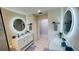 Bathroom featuring double sinks with marble countertops and elegant, lit mirrors at 2399 Bendway Dr, Port Charlotte, FL 33948
