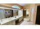 Large bathroom with dual sinks, vanity, and mirrored wall with a step-up tub at 2399 Bendway Dr, Port Charlotte, FL 33948