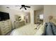 A light filled bedroom displays an inviting bed with yellow pattern, mirrored closet doors and a ceiling fan at 2399 Bendway Dr, Port Charlotte, FL 33948