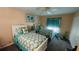 Bright bedroom featuring two beds with white frames, teal accents, and a ceiling fan at 2399 Bendway Dr, Port Charlotte, FL 33948