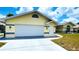 Attached two car garage of a well-maintained home with manicured lawn at 2399 Bendway Dr, Port Charlotte, FL 33948