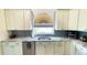 Kitchen featuring an arched window over the sink, white cabinets, and stainless appliances at 2399 Bendway Dr, Port Charlotte, FL 33948