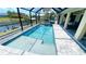 Inviting screened pool area with a sparkling blue pool and ample patio space, perfect for relaxation and entertaining at 2399 Bendway Dr, Port Charlotte, FL 33948