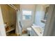 Well-lit bathroom featuring a tiled shower with built-in seating, along with a modern sink and toilet at 24239 Yacht Club Blvd, Punta Gorda, FL 33955