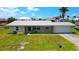 Charming home with a well-maintained lawn, attached garage, and metal roof at 24239 Yacht Club Blvd, Punta Gorda, FL 33955