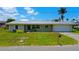 Charming single-story home with a metal roof, well-maintained lawn, and an attached garage in a serene setting at 24239 Yacht Club Blvd, Punta Gorda, FL 33955