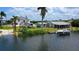 Waterfront property with boat lift and dock, featuring a charming home and lush tropical landscaping at 24239 Yacht Club Blvd, Punta Gorda, FL 33955