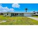 Charming single-story home featuring a well-manicured lawn, attached garage, and a durable metal roof at 24239 Yacht Club Blvd, Punta Gorda, FL 33955