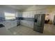 Modern kitchen with white cabinetry, stainless steel appliances, a tile backsplash, and a view into the dining area at 24239 Yacht Club Blvd, Punta Gorda, FL 33955