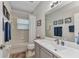 Bright bathroom featuring a shower/tub combo with framed wall art and a large vanity mirror at 24358 Folkstone Ave, Punta Gorda, FL 33980