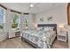 Cozy bedroom with a comfy bed with tropical-themed patterns and lots of natural light from the two arched windows at 24358 Folkstone Ave, Punta Gorda, FL 33980