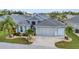 Beautiful home featuring a well-kept lawn, tropical landscaping, and a spacious two-car garage at 24358 Folkstone Ave, Punta Gorda, FL 33980