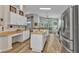 Spacious kitchen with white cabinets, stainless steel appliances and breakfast bar at 24358 Folkstone Ave, Punta Gorda, FL 33980
