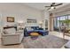 Cozy living room featuring a comfortable blue sectional sofa and an elegant area rug at 24358 Folkstone Ave, Punta Gorda, FL 33980