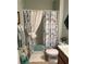 Bathroom features light floral shower curtain, white toilet, and an artistic hanging decoration at 25008 Lalique Pl, Punta Gorda, FL 33950