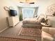 Cozy bedroom featuring a decorative rug, dresser with TV, and soft natural light from the window at 25008 Lalique Pl, Punta Gorda, FL 33950
