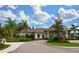 Attractive clubhouse features lush landscaping, palm trees, and a circular driveway; inviting at 25008 Lalique Pl, Punta Gorda, FL 33950