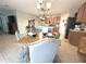 Spacious open dining area with wood table, modern chandelier, and seamless flow to kitchen and living areas at 25008 Lalique Pl, Punta Gorda, FL 33950