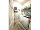 A compact laundry room equipped with a washer, dryer, shelving, and themed decor at 25008 Lalique Pl, Punta Gorda, FL 33950