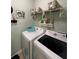 Efficient laundry room features a side-by-side washer and dryer with overhead storage at 25008 Lalique Pl, Punta Gorda, FL 33950