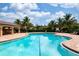 Resort-style pool surrounded by palm trees and a covered patio area for relaxation and entertainment at 25008 Lalique Pl, Punta Gorda, FL 33950