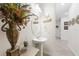 Powder room showcasing pedestal sink, modern mirror, and stylish decor with a view into the hallway at 2515 Sherman Oak Dr, North Port, FL 34289