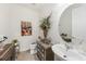 Bathroom with tiled flooring, pedestal sink, decorative mirror, complemented by an art piece that adds a touch of color at 2515 Sherman Oak Dr, North Port, FL 34289