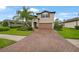 Charming two-story home featuring a brick driveway, well-manicured lawn, and attractive landscaping at 2515 Sherman Oak Dr, North Port, FL 34289
