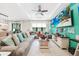 Bright living room features a large sectional, neutral tile flooring, and access to a dining area at 2515 Sherman Oak Dr, North Port, FL 34289