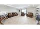 Living room featuring tiled flooring, a comfortable sofa, and natural light creating a cozy and inviting space at 2515 Sherman Oak Dr, North Port, FL 34289