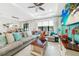 Bright living room features a large sectional, neutral tile flooring, and access to a dining area at 2515 Sherman Oak Dr, North Port, FL 34289