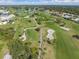 Aerial view of a golf course community featuring manicured greens, lakes and mature trees at 25275 Rampart Blvd # 1504, Punta Gorda, FL 33983