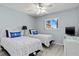 Cozy bedroom with two beds, blue accents, ceiling fan, and a window with a view at 25275 Rampart Blvd # 1504, Punta Gorda, FL 33983