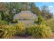 Deep Creek community sign surrounded by mature landscaping and colorful flower beds at 25275 Rampart Blvd # 1504, Punta Gorda, FL 33983