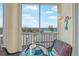 Relax on the balcony with coastal views, comfortable seating, and a table for enjoying the scenery at 2590 N Beach Rd # 5, Englewood, FL 34223